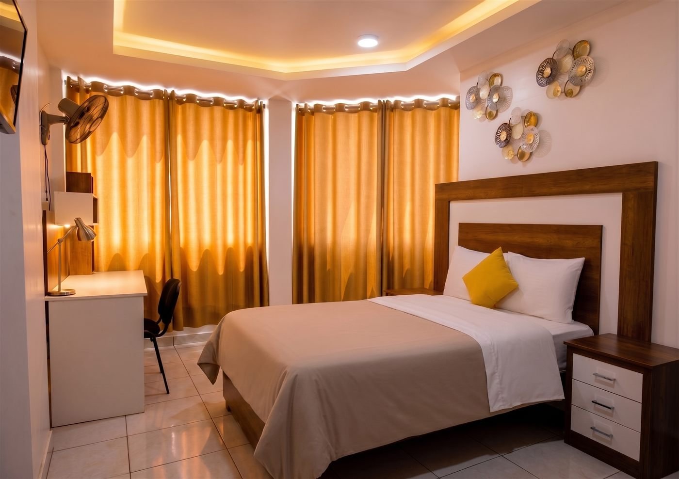 Habitación con cortinas doradas y detalle decorativo en pared