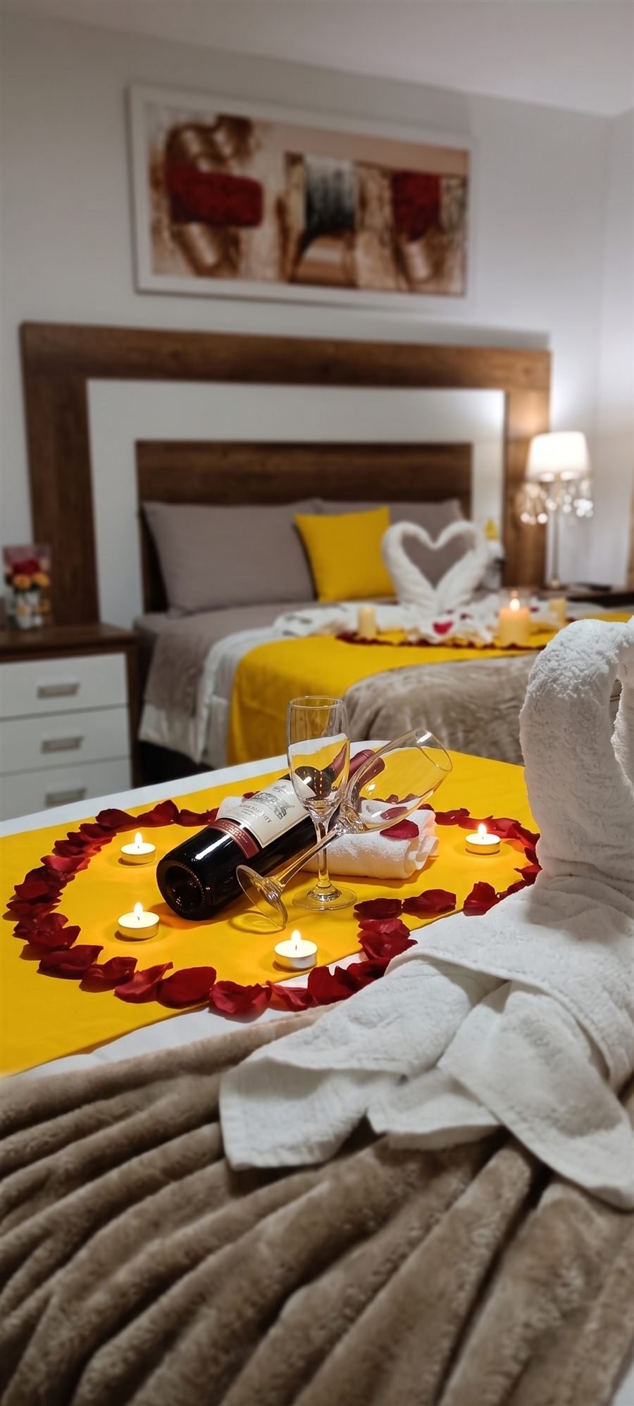 Habitación decorada para la promoción Romántica, con vino, copas y velas